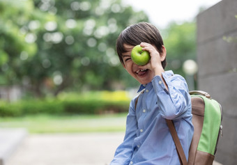 可爱的小男孩穿<strong>蓝色</strong>的衬衫和携带学生背包显示苹果为早餐之前学校早餐重要的为孩子发展<strong>健康</strong>和<strong>健康</strong>