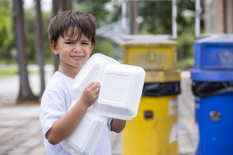 男孩保持的聚苯乙烯泡沫塑料盒子把的垃圾聚苯乙烯泡沫塑料盒子为外卖食物首页导致污染和不能重用