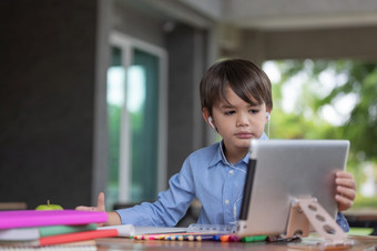 孩子自我隔离使用平板电脑为他的家庭作业孩子做使用数字平板电脑搜索信息互联网在科维德锁下来<strong>首页</strong>学校<strong>教育</strong>社会距离电子学习在线<strong>教育</strong>