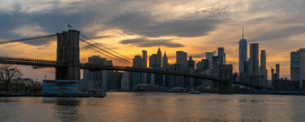 横幅和封面场景新纽约城市景观与布鲁克林桥在的东河的日落时间美国市中心天际线体系结构和运输概念