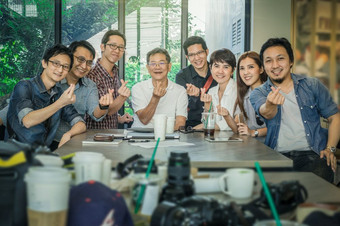集团亚洲业务人与休闲西装做小心与快乐行动和庆祝的办公室咖啡商店人业务集团概念