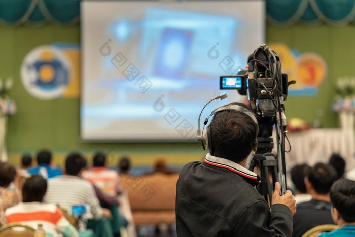后一边视频摄影师采取照片亚洲演讲者与休闲西装的阶段现在的屏幕的会议大厅研讨会会议事件和研讨会生产概念