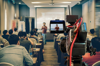 特写镜头视频记录的亚洲演讲者与休闲西装的阶段在的演讲屏幕的会议房间业务教育研讨会事件和研讨会概念