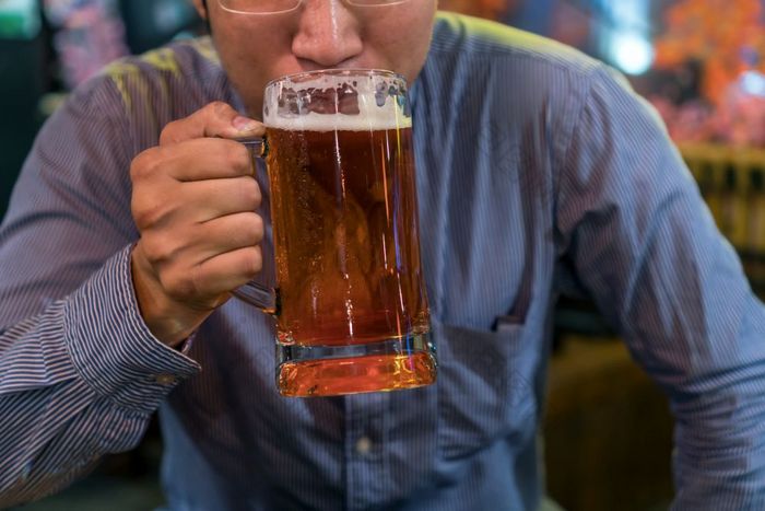 亚洲商人幸福行动和喝啤酒后工作成功工作酒吧和餐厅放松和喝概念