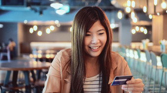 亚洲女商人休闲西装使用的信贷卡与电脑为在线购物联合办公空间业务技术和生活方式概念