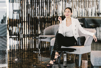 肖像亚洲女商人穿正式的西装坐着的沙发现代<strong>游说</strong>团体办公室共同办公空间咖啡打破休闲时尚和生活方式后工作时间业务人概念