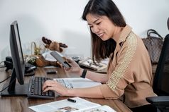 亚洲女商人正式的西装写作和工作与电脑和移动办公室业务和项目计划为客户服务概念