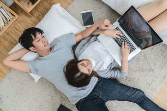 前视图情人使用的数字平板电脑<strong>现代</strong>首页睡觉的<strong>地毯</strong>地板上夫妇情人和生活方式概念