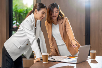 两个亚洲女商人工作与的合作伙伴业务通过技术移动PC现代会议房间办公室工作空间咖啡打破合作伙伴和的同事概念