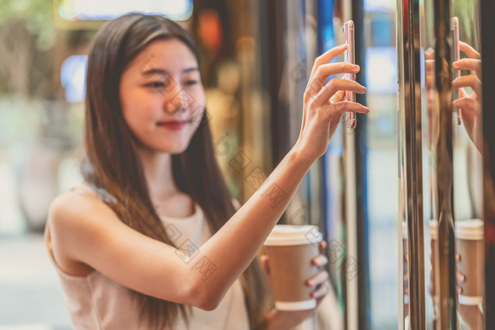 特写镜头亚洲年轻的女人手使用聪明的移动电话扫描的电影票机为买和得到的优惠券部门商店生活方式和休闲娱乐和技术扫描仪概念