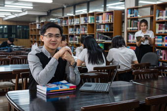 肖像亚洲老师给教训集团<strong>大学</strong>学生为回答的问题的图书馆和教室<strong>大学</strong>教育概念