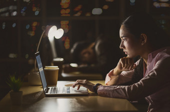 亚洲女商人工作<strong>硬</strong>晚些时候与她的技术移动PC办公室客户服务和调用中心部门<strong>硬</strong>工人和加班她的的同事们困了低光环境