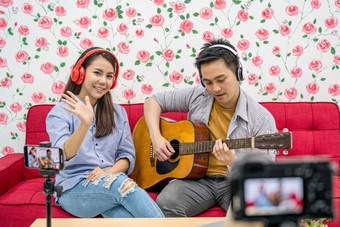 亚洲视频博客结婚了夫妇玩和分享的音乐出席者通过移动电话社会媒体通道相机采取视频和流生活视频博客和影响者自由概念