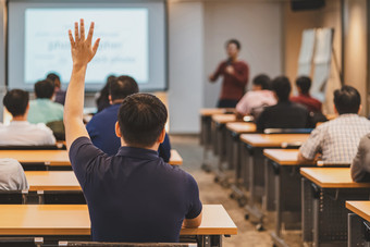 后视图观众提高手响应为回答的问题的会议房间会议大厅在亚洲演讲者的<strong>阶段</strong>研讨会业务和教育概念