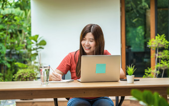 亚洲业务女人使用技术移动PC和写作笔记本为工作从首页户外首页和花园创业公司和业务老板社会距离和自我责任