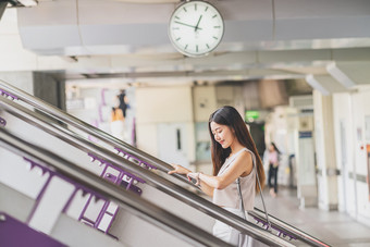年轻的亚洲女人乘客使用聪明的移动电话和走的楼梯地铁站当旅行大城市日本中国人朝鲜文<strong>生活</strong>方式和每天<strong>生活</strong>通勤和运输