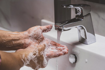 特写镜头手洗与铬水龙头和肥皂为冠状病毒流感大流行预防浴室自我责任清洁手卫生电晕病毒保护概念