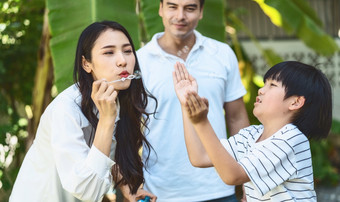 亚洲家庭包括父亲妈妈。和儿子玩的泡沫吹幸福感觉<strong>在一起</strong>公园户外和房子花园温暖的家庭首页学校假期和假期<strong>在一起</strong>