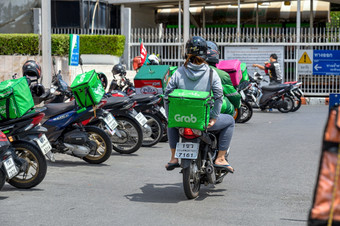 曼谷泰国4月抓住食物车手骑的摩托车出食物交付服务点4月曼谷泰国科维德爆发使食物交付服务受欢迎的