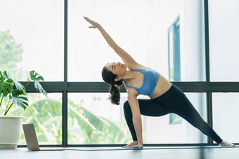 亚洲女人练习瑜伽从首页与移动PC当科维德爆发和封锁健康的冥想锻炼锻炼首页冠状病毒流感大流行和检疫体育和医疗保健概念
