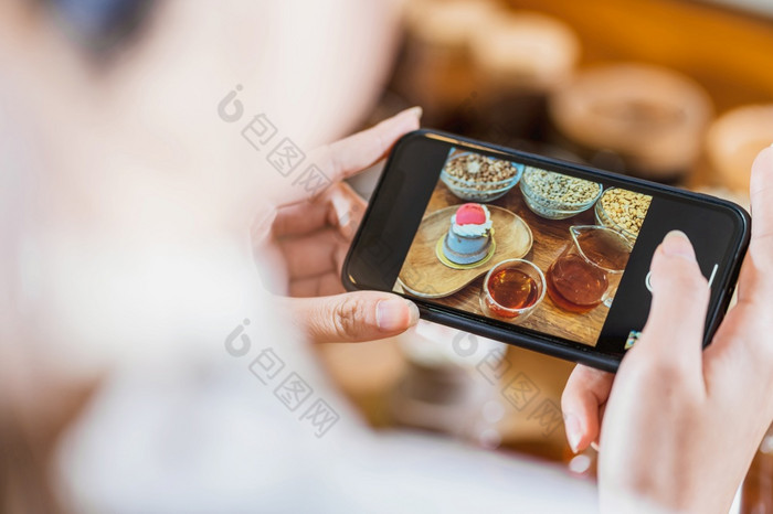 特写镜头移动电话采取照片蛋糕面包店与蜂蜜服务与咖啡壶的木表格咖啡馆商店和餐厅甜蜜的甜点和咖啡时间为社会网络概念