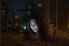 亚洲女人睡觉和使用聪明的移动电话为社会网络视频会议调用当科维德爆发检疫和冠状病毒流感大流行社会距离和新正常的概念