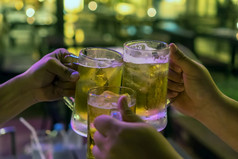 三个眼镜啤酒干杯在一起之间的朋友的低光酒吧和餐厅放松和喝概念