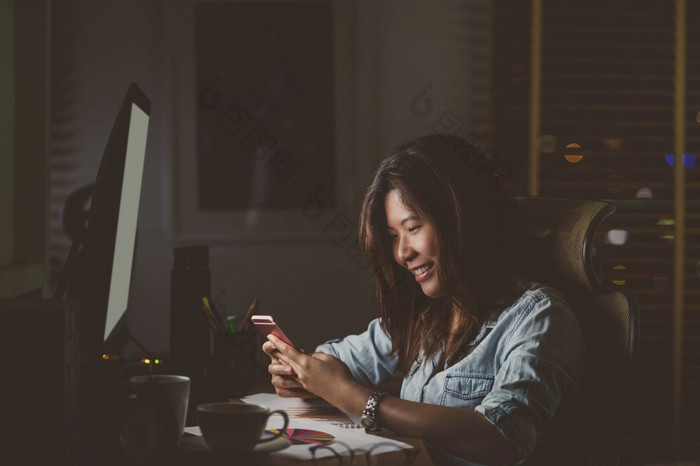 肖像亚洲女商人坐着和工作硬与幸福行动的表格与前面电脑桌面工作场所晚些时候时间工作硬和太晚些时候概念