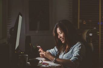 肖像亚洲女商人坐着和工作硬与幸福行动的表格与前面<strong>电脑桌面</strong>工作场所晚些时候时间工作硬和太晚些时候概念