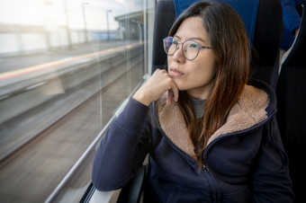 亚洲年轻的夫人乘客坐着抑郁情绪旁边的窗口内部火车哪一个旅行之间的小镇当旅行独自一人为逃避的混乱旅行者和抑制概念