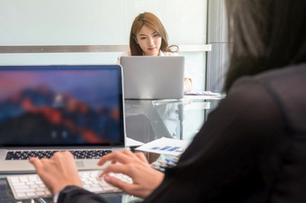 亚洲年轻的女商人与休闲西装坐着和使用的技术移动PC的现代工作场所业务生活方式和技术概念