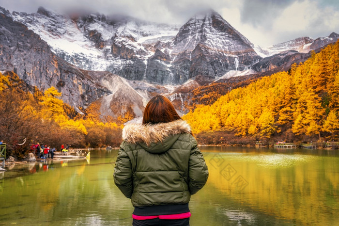 回来一边亚洲旅行者女人看和观光在的珍珠湖与雪山秋天季节雅自然储备中国旅行和旅游著名的的地方和具有里程碑意义的概念