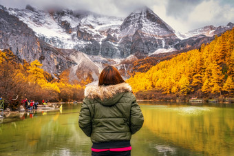 回来一边亚洲旅行者女人看和观光在的珍珠湖与雪山秋天季节雅自然储备中国旅行和旅游著名的的地方和具有里程碑意义的概念