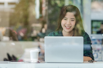 肖像亚洲女商人休闲西装使用技术移动PC为工作幸福行动的桌子上旁边的玻璃现代办公室业务老板和企业家概念