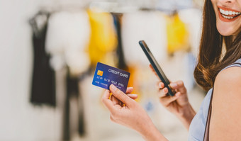 横幅和网络页面封面模板亚洲女人使用信贷卡与移动电话为在线购物部门商店在的衣服商店商店背景信贷卡模型