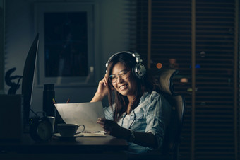 肖像亚洲女商人坐着和工作硬与幸福行动的表格与前面电脑桌面工作场所晚些时候时间工作硬和太晚些时候概念