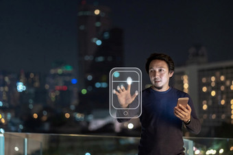 亚洲有创意的自由职业者使用聪明的移动电话与authentificate指纹的金融区区域曼谷河一边泰国技术与职业生涯概念