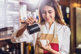 亚洲咖啡师<strong>倒牛奶</strong>杯咖啡哪一个表示与拿铁卡布奇诺咖啡为客户订单咖啡商店小业务老板和启动咖啡商店和餐厅概念