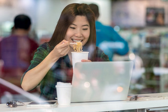 肖像亚洲女商人休闲西装吃面条与幸福行动冲小时的桌子上旁边的玻璃现代办公室业务工作硬概念
