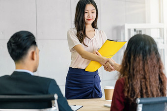 年轻的亚洲女人研究生手摇与两个经理欢迎之前开始工作面试与积极的运动会议房间业务招聘新成员工作面试第一个印象概念