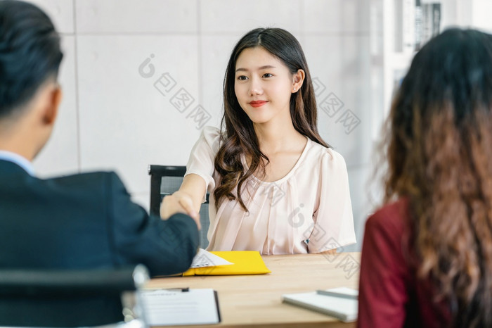 年轻的亚洲女人研究生手摇与两个经理欢迎之前开始工作面试与积极的运动会议房间业务招聘新成员工作面试第一个印象概念