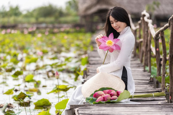 肖像美丽的越南女人与传统的越南他持有的粉红色的<strong>莲花</strong>坐着的木桥<strong>大莲花</strong>湖越南爱山东南亚洲旅行概念