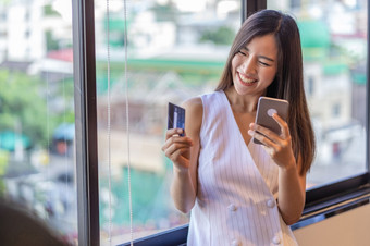 亚洲女商人休闲西装做在线购物使用信贷卡和支付通过聪明的移动电话应用程序技术移动PC现代办公室业务和生活方式概念