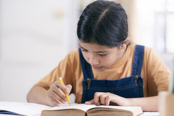 亚洲女孩阅读和做家庭作业她的首页教育和自<strong>我学</strong>习概念
