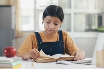 亚洲女孩阅读和做家庭作业她的首页教育和自<strong>我学</strong>习概念