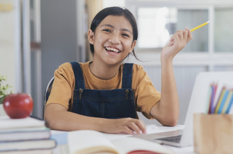 快乐亚洲女孩学习在线首页教育和电子学习概念