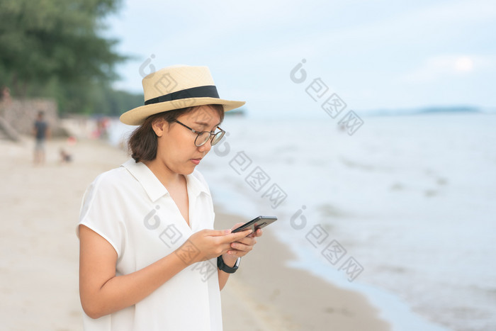 美丽的年轻的女人持有智能手机订单取图片你自己从相机电话自拍旅游概念独自一人自画像摄影