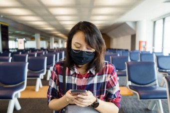 女人穿脸面具旅行的机场<strong>新生活</strong>方式旅行后新冠病毒社会距离和旅行泡沫概念