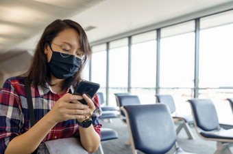 女人穿脸面具旅行的机场<strong>新生活方式</strong>旅行后新冠病毒社会距离和旅行泡沫概念