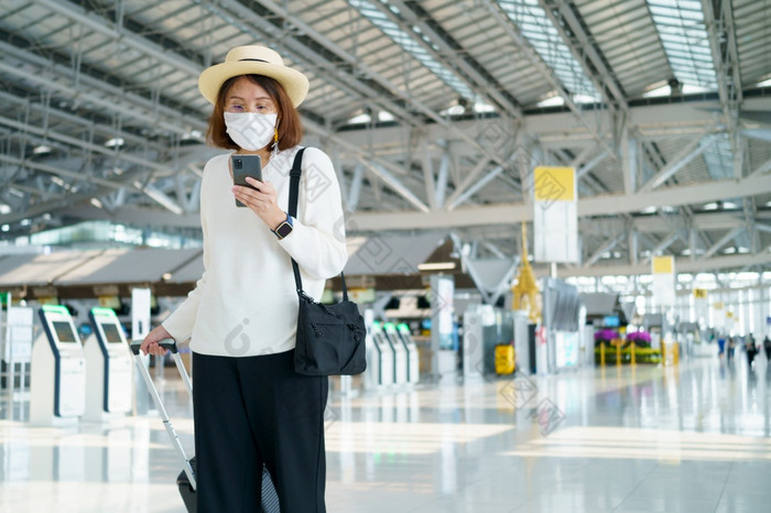 新正常的旅游穿脸面具旅行的机场新生活方式旅行后新冠病毒社会距离医疗保健系统保持安全和旅行泡沫概念